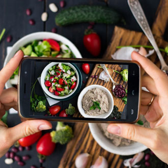 Lady taking photos of vegan food at vegan festival